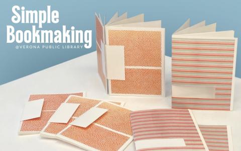 A display of two types of hand-made books. Seven total books. Of which, 2 are upright and open, 5 are lying flat and closed.