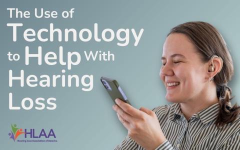 a woman with a hearing aid smiling looking at a smart phone