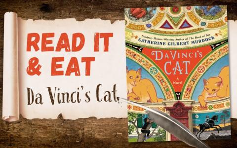 old wooden table with a scroll that says "Read It & Eat: Da Vinci's Cat" next to the book's cover