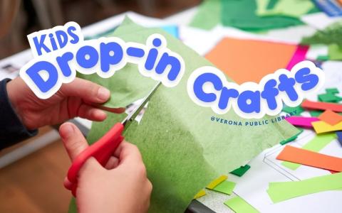 young person cutting a piece of green paper