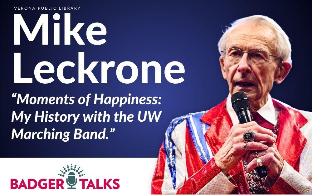 Mike Leckrone wearing a red and white sequined suit jacket holding a microphone